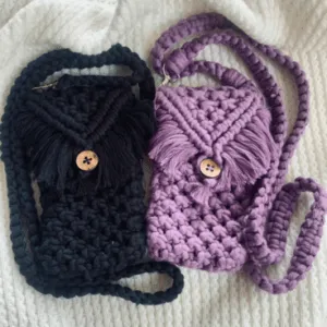 Handcrafted macramé phone slings in black and purple with fringe flap and wooden button, featuring chunky braided straps