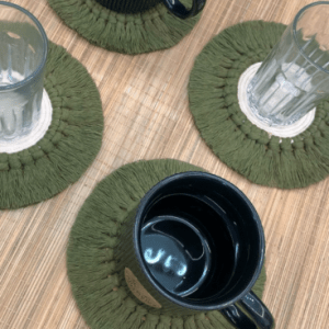 Handcrafted 6-inch round macramé coaster in sage green and off white cotton with fringe border