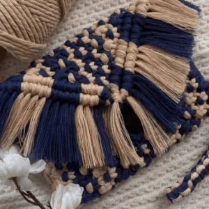 Handmade navy blue and beige macramé clutch bag, featuring braided wristlet strap and fringe flap, crafted from cotton cord