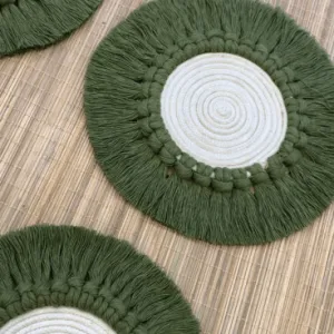 Handcrafted 6-inch round macramé coaster in sage green and off white cotton with fringe border