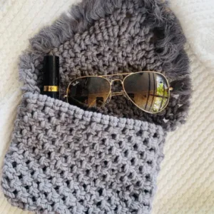 Handcrafted grey macramé bag with fringed flap, artisan knotting, and spacious cotton body