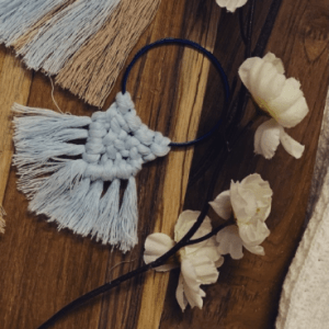 Handknotted mini macramé wall hanging bangles in earthy beige, light blue, and deep blue, each with a soft fringe