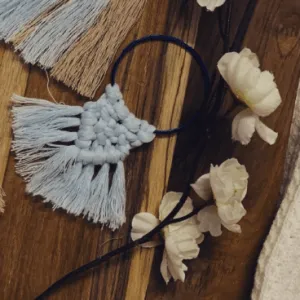 Handknotted mini macramé wall hanging bangles in earthy beige, light blue, and deep blue, each with a soft fringe